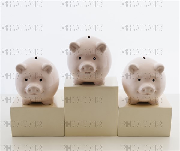 Three piggy banks in arranged on sports podium. Photo : Jamie Grill