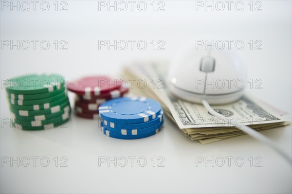 Roulette tokens, dollar bills and computer mouse. Photo : Jamie Grill