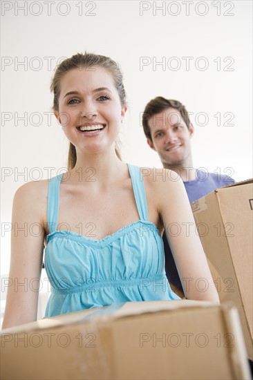 Young couple holding cardboard boxes. Photo : Jamie Grill