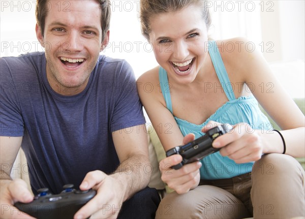 Young couple playing computer games. Photo : Jamie Grill