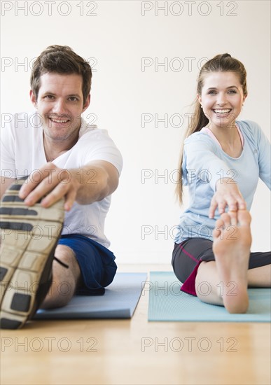 Happy young couple exercising together. Photo: Jamie Grill