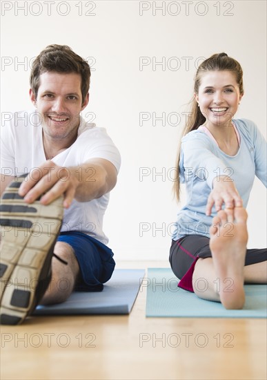 Happy young couple exercising together. Photo : Jamie Grill