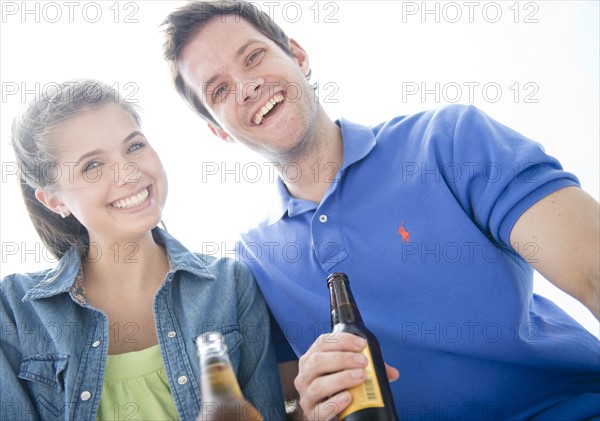 Happy young couple drinking beer. Photo : Jamie Grill