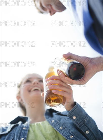 Happy young couple drinking beer. Photo : Jamie Grill