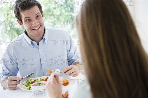 Happy young couple eating together. Photo: Jamie Grill