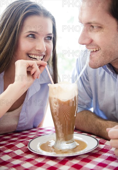 Happy young couple drinking milk shake . Photo: Jamie Grill