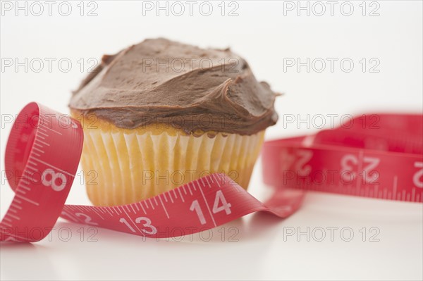 Studio Shot of cupcake and tape measure. Photo : Jamie Grill