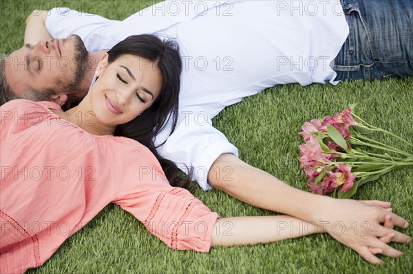 Couple lying together on grass. Photo : Jamie Grill