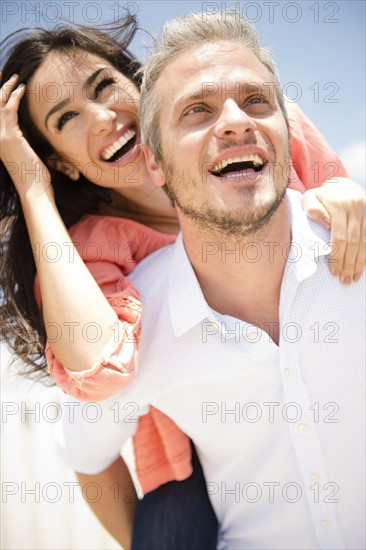 Young woman piggy back riding on man. Photo: Jamie Grill