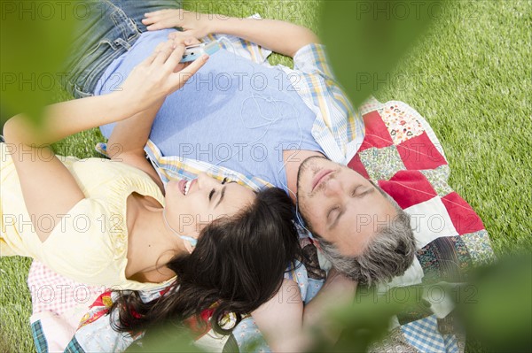 Couple lying together on grass. Photo : Jamie Grill