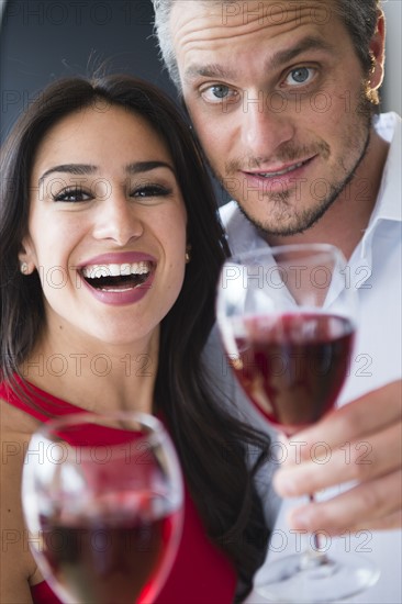 Couple toasting with red wine. Photo : Jamie Grill