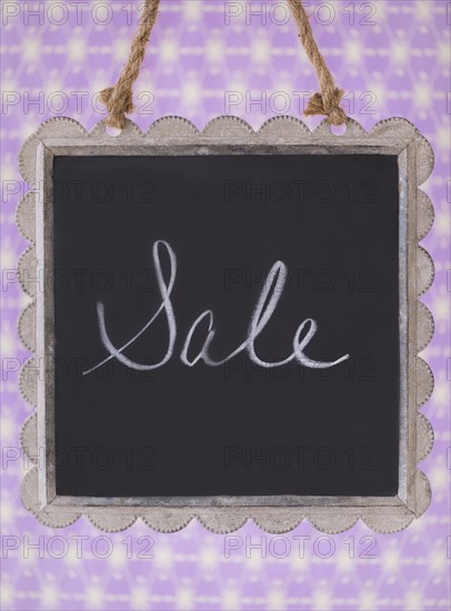 Studio shot of small blackboard with word Sale. Photo : Daniel Grill