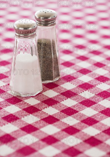 Salt and pepper shakers on checked tablecloth. Photo: Daniel Grill