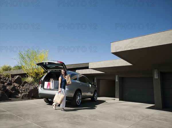 Woman with groceries leaving car. Photo: Erik Isakson