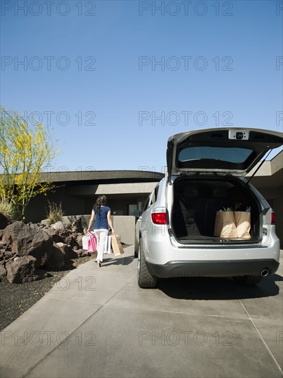 Car with open trunk with groceries.