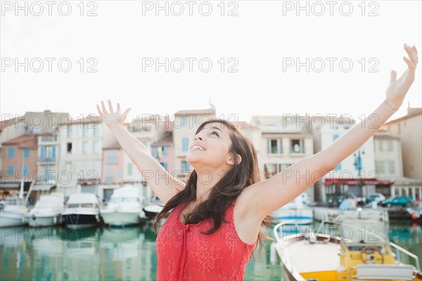 France, Cassis, Portrait of young woman with arms spread. Photo : Mike Kemp