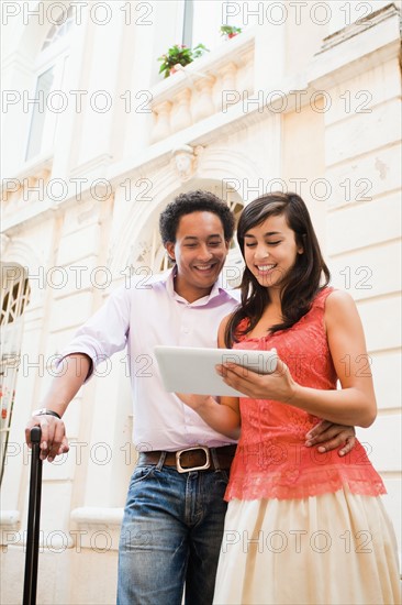 France, Cassis, Couple using digital tablet on street. Photo : Mike Kemp