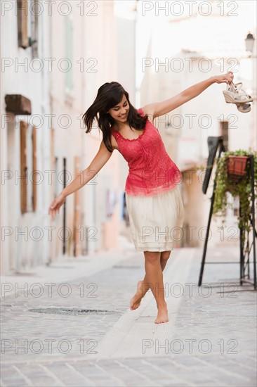 France, Cassis, Young woman balancing on curbstone. Photo : Mike Kemp