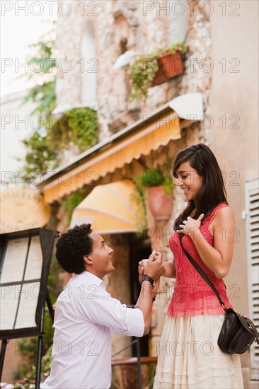 France, Cassis, Man kneeling before young woman. Photo : Mike Kemp