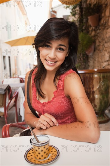 France, Cassis, Portrait of young woman sitting in cafe. Photo : Mike Kemp