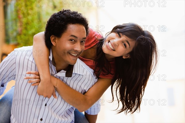 Couple laughing and piggybacking. Photo : Mike Kemp