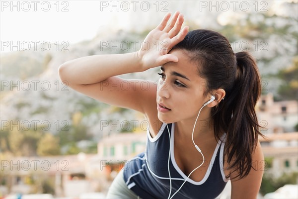 France, Marseille, Young woman in tracksuit and with headphones. Photo: Mike Kemp