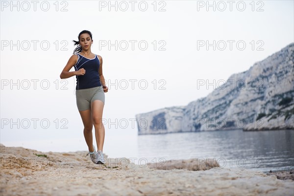 France, Marseille, Woman jogging by seaside. Photo : Mike Kemp