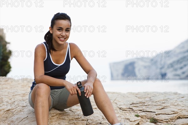 France, Marseille, Young woman resting after run. Photo : Mike Kemp