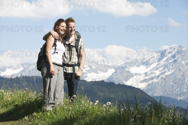 Switzerland, Leysin, Hikers standing on meadow in Alps. Photo: Mike Kemp