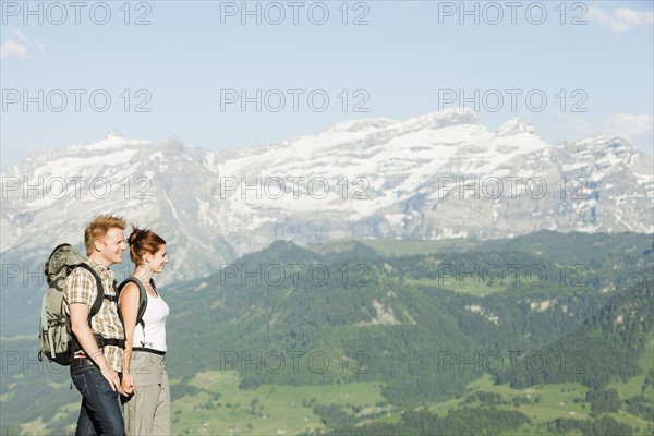 Switzerland, Leysin, Hikers marching through Alpine landscape. Photo: Mike Kemp