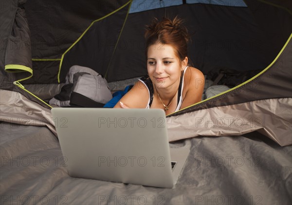 Hiker in tent using laptop. Photo: Mike Kemp