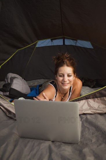 Hiker in tent using laptop. Photo: Mike Kemp