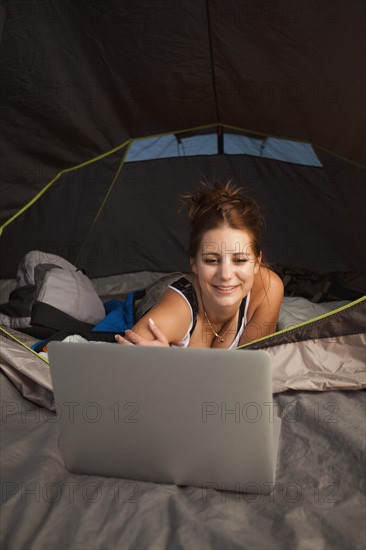 Hiker in tent using laptop. Photo : Mike Kemp