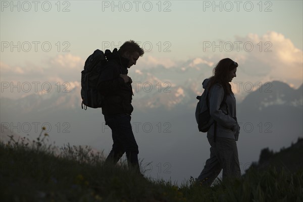 Switzerland, Leysin, Hikers marching through Alpine landscape. Photo: Mike Kemp