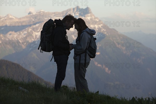 Switzerland, Leysin, Silhouettes of hikers looking at each other. Photo : Mike Kemp