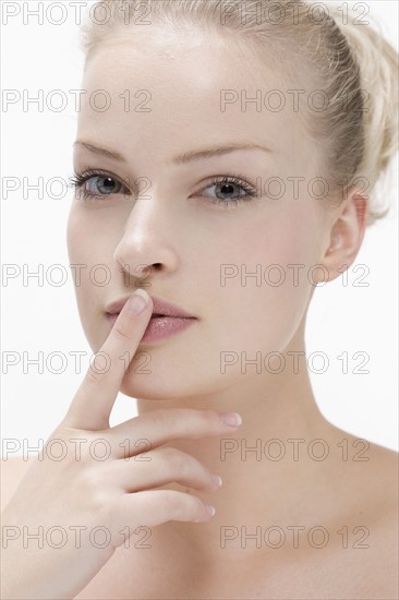Beauty portrait of woman with finger on lips. Photo: Jan Scherders