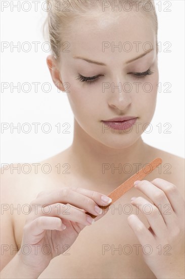 Beauty portrait of woman using nail file. Photo : Jan Scherders