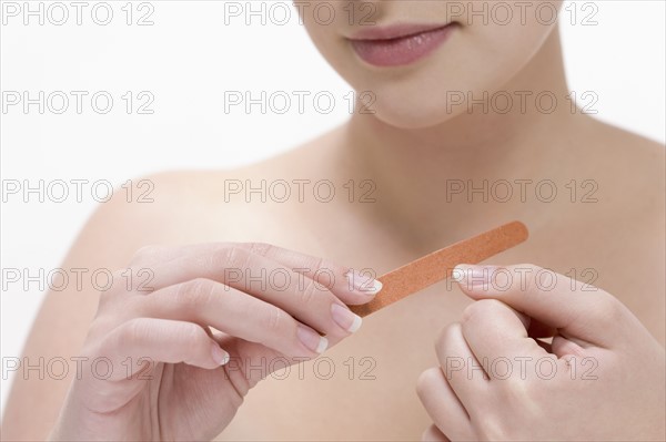 Beauty shot of woman using nail file. Photo : Jan Scherders