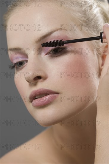 Beauty portrait of woman using mascara. Photo : Jan Scherders