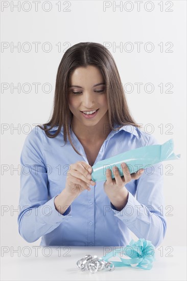 Studio shot of woman opening present. Photo: Jan Scherders