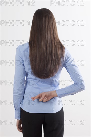 Back view of woman with crossed fingers. Photo : Jan Scherders