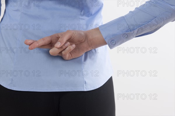 Back view of woman with crossed fingers. Photo : Jan Scherders