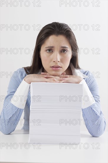 Studio shot of woman with stack of documents. Photo : Jan Scherders