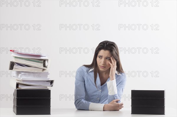 Studio shot of woman with stack of documents. Photo : Jan Scherders