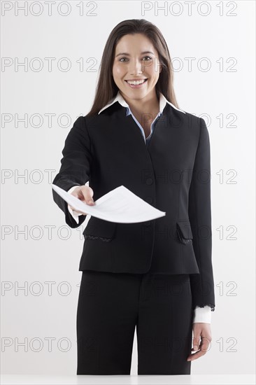 Studio shot of businesswoman holding document. Photo : Jan Scherders