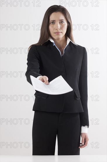 Studio shot of businesswoman holding document. Photo : Jan Scherders