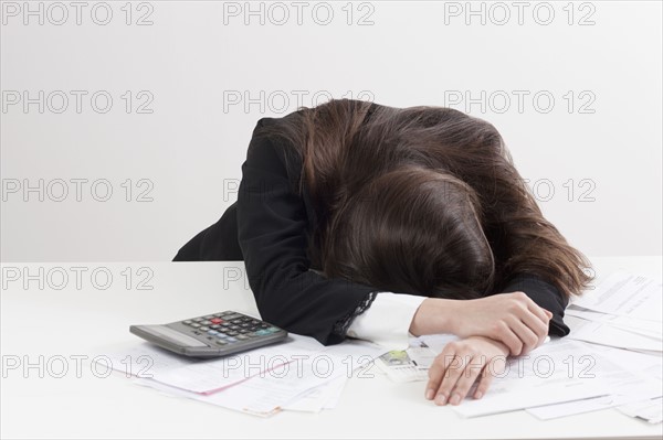 Studio shot of businesswoman with calculator and bills. Photo : Jan Scherders