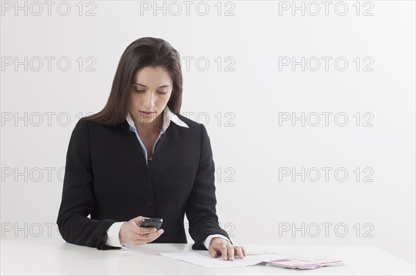 Young woman paying bill with her mobile phone. Photo : Jan Scherders