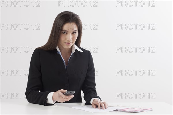 Young woman paying bill with her mobile phone. Photo: Jan Scherders