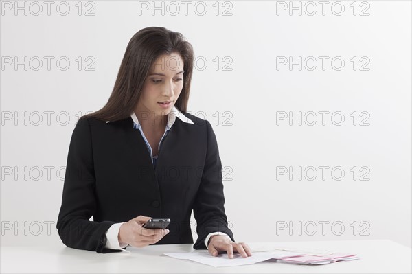 Young woman paying bill with her mobile phone. Photo : Jan Scherders